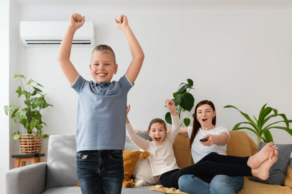 Diversión en familia, niños felices viendo televisión en sofá con padres en salón moderno, ambiente cómodo y relajado, entretenimiento y ocio en hogar.