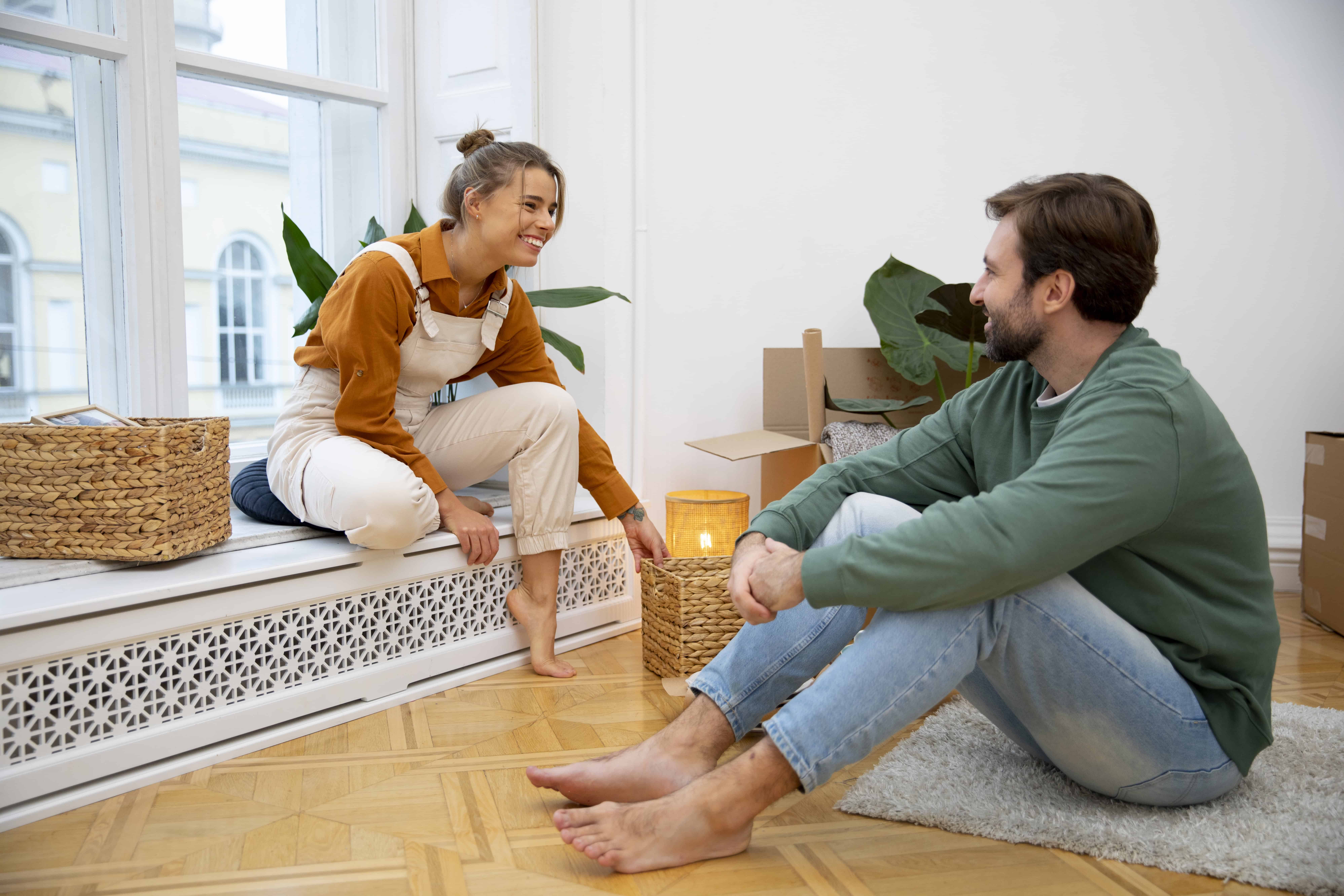 Conserje y cliente conversando en interior de apartamento con elementos de decoración natural y moderna.